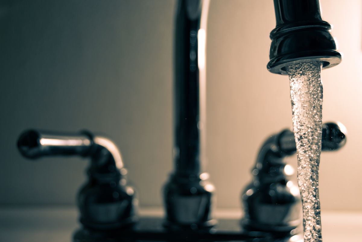 Clean water flowing from a modern steel faucet